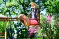 Romantic little girl on the swing, sweet dreams. Small kid playing in summer. childhood daydream .teen freedom Royalty Free Stock Photo