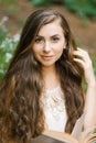 Romantic long haired young beautiful woman holding a book and stroking her hai