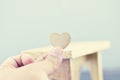 Romantic look hand holding heart made from wood