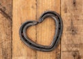 Romantic love heart shaped horse shoe created by farrier laid on rustic vintage wood Royalty Free Stock Photo