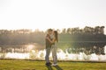 Romantic, love, people concept - young couple hugging near the lake at the sunset Royalty Free Stock Photo