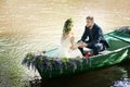 Romantic love story in boat. Woman with wreath and white dress. European tradition Royalty Free Stock Photo