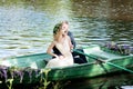Romantic love story in boat. Woman with wreath and white dress. European tradition Royalty Free Stock Photo