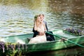 Romantic love story in boat. Woman with wreath and white dress. European tradition Royalty Free Stock Photo