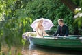 Romantic love story in boat. Woman with wreath and white dress. European tradition Royalty Free Stock Photo