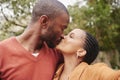 Romantic, in love and young couple kissing and taking a selfie outdoors in nature on a picnic. Happy, loving and African Royalty Free Stock Photo