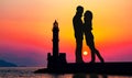 Romantic lovers with lighthouse on a background. Lighthouse of Chania at summer sunset , Crete , Greece