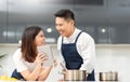 Romantic loving Asian couple cooking and using digital tablet in modern kitchen at home