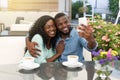 Romantic loving couple drinking coffee and taking picture, having a date in cafe