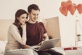 Romantic loving couple having movie night together while sitting on double bed