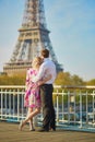 Romantic couple kissing near the Eiffel tower in Paris, France Royalty Free Stock Photo