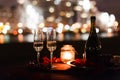 Romantic luxury evening with champagne setting with two glasses, rose petails and candles