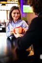 Romantic man giving birthday gift to beautiful emotional woman. Portrait of lovely couple sitting together in cafe, dating. Royalty Free Stock Photo