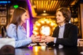 Romantic man giving birthday gift to beautiful emotional woman. Portrait of lovely couple sitting together in cafe, dating. Royalty Free Stock Photo