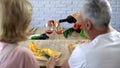 Romantic man pouring red wine in glasses, happy couple cooking together at home Royalty Free Stock Photo