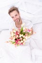 romantic man smile with tulips for 8 march. photo of romantic man with march tulips bouquet. Royalty Free Stock Photo