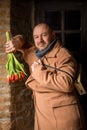 Romantic man smiling with a bouquet of flowers - tulips. A middle-aged man with a short haircut in a large coat Royalty Free Stock Photo