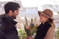 Romantic Man Surprising Young Woman With Bouquet Of Flowers As They Meet In City Park