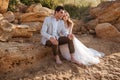 Romantic married couple sitting on the beach