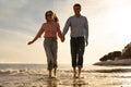 Romantic Mature Couple Holding Hands While Running On The Beach Together Royalty Free Stock Photo