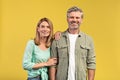 Romantic mature couple. Portrait of happy european middle aged man and woman posing on yellow background Royalty Free Stock Photo