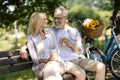 Romantic Mature Couple With Takeaway Coffee Relaxing On Bench In Summer Park Royalty Free Stock Photo