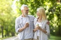 Romantic Mature Couple Walking Together In Park And Drinking Takeaway Coffee Royalty Free Stock Photo