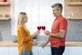 Romantic middle aged couple drinking red wine at kitchen Royalty Free Stock Photo