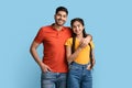 Romantic millennial arab couple posing together over blue studio background