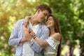 Romantic millennial couple hugging and feeling happy in park
