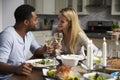 Romantic mixed race couple making a toast at meal in kitchen Royalty Free Stock Photo