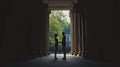 A romantic moment between two lovers under ancient columns in soft light. Their silhouettes create a beautiful scene of connection Royalty Free Stock Photo