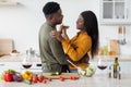 Romantic Moments. Happy Black Couple Dancing And Drinking Red Wine In Kitchen Royalty Free Stock Photo