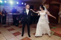 Romantic newlywed couple dancing, handsome groom and beautiful happy bride first dance while holding hands at restaurant wedding Royalty Free Stock Photo