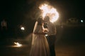 Romantic newlyweds kissing at night in front of flaming heart