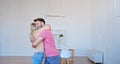 Romantic newlyweds with large brown cardboard boxes put things on floor pile in new apartment Royalty Free Stock Photo