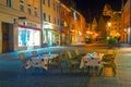 Romantic night scene of street cafe with two tables and old street with citylights on background, Fussen, Germany Royalty Free Stock Photo