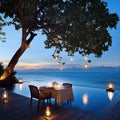 Romantic Dinner Table Setting by Infinity Pool at Sunset, Ocean View, Lanterns Royalty Free Stock Photo