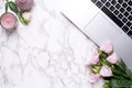 Romantic office background with flowers, candle and keyboard on a marble table