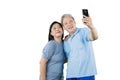 Romantic old couple taking a selfie photo on studio Royalty Free Stock Photo