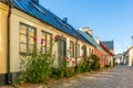 Romantic old house with hollyhocks on the pavement Royalty Free Stock Photo