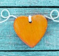 Romantic orange wooden heart on turquoise wood