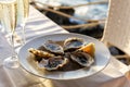 Plate with Raw Oysters with lemon and ice, glasses of champagne. Italy,