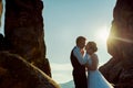 Romantic outdoor portrait of the beautiful young newlywed couple going to kiss during the sunset. Royalty Free Stock Photo