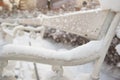 Romantic outdoor white bench covered with snow