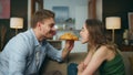 Romantic pair eating croissant home zoom on. Loving man woman face bitting bun