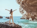 Beautiful young woman on wild rocky beach. Royalty Free Stock Photo