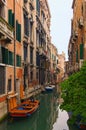 Romantic and peaceful scene of Venice city. Medieval buildings reflected in turquoise water. Boats moored along the buildings. Royalty Free Stock Photo