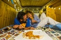 Romantic people adult young couple in love enjoy the little tiny house inside an old restored vintage van eating pizza together