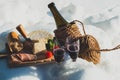 Romantic picnic with Lambrusco cheese baguette and ham on snow. Traditional Italian food and drink in sunny winter day. Royalty Free Stock Photo